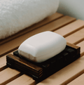 Bar of coconut-scented soap from My Store with a smooth, creamy texture in a clear soap dish.