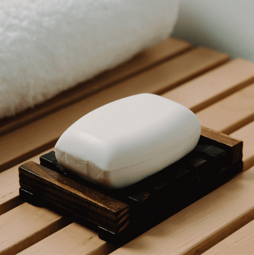 Bar of coconut-scented soap from My Store with a smooth, creamy texture in a clear soap dish.