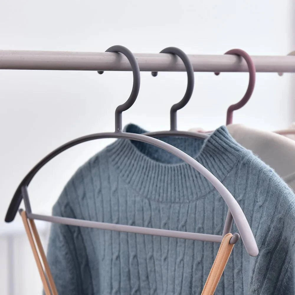 Plastic household clothes hanger with wide shoulder and arc design, seamless semi-circular hanging organizer for garments.